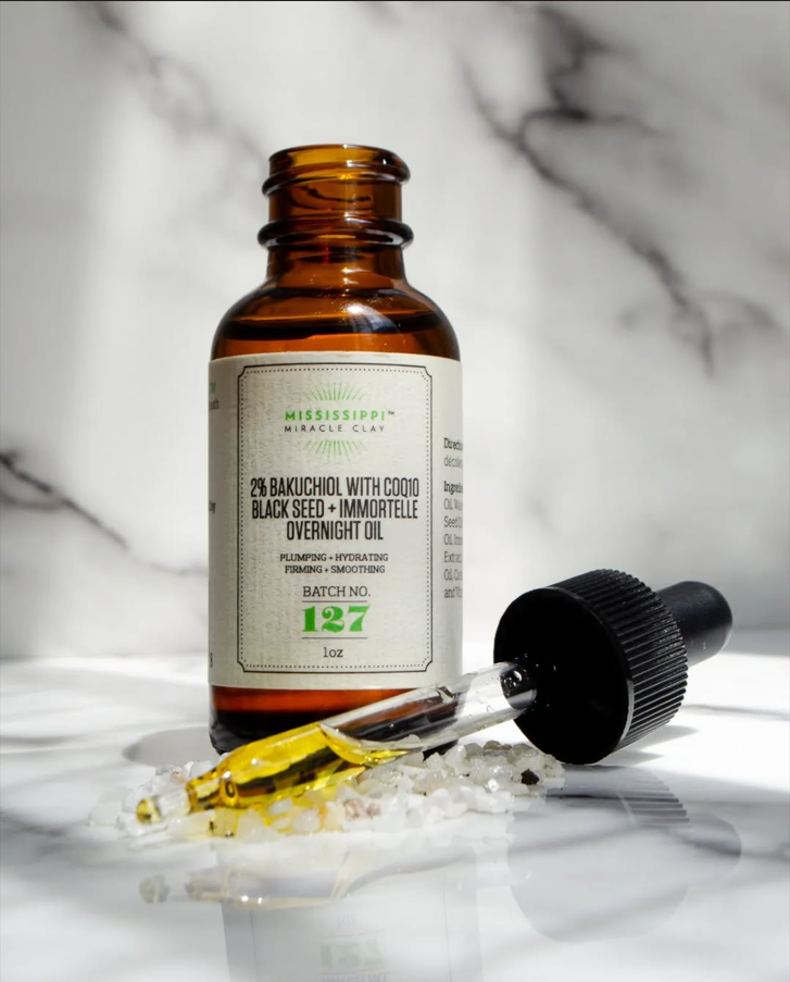 2% Bakuchiol Overnight Oil on white marble with its dropper, a gentle retinol alternative