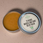 Open tin of 72 Herbs Muscle and Joint Relief Balm showing the herbal salve