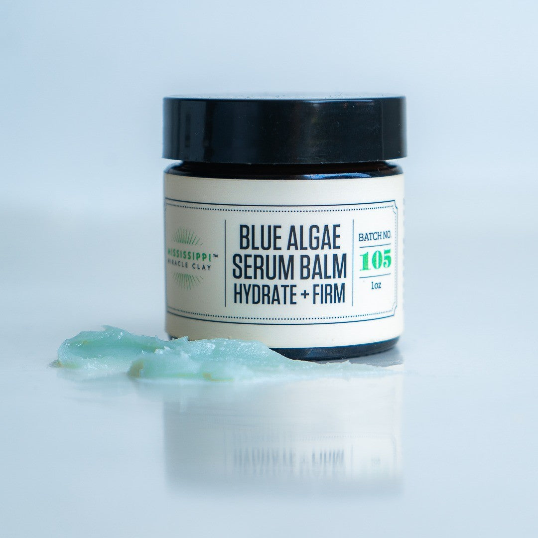 Blue Algae Serum Balm jar with a swatch of the blue-green balm