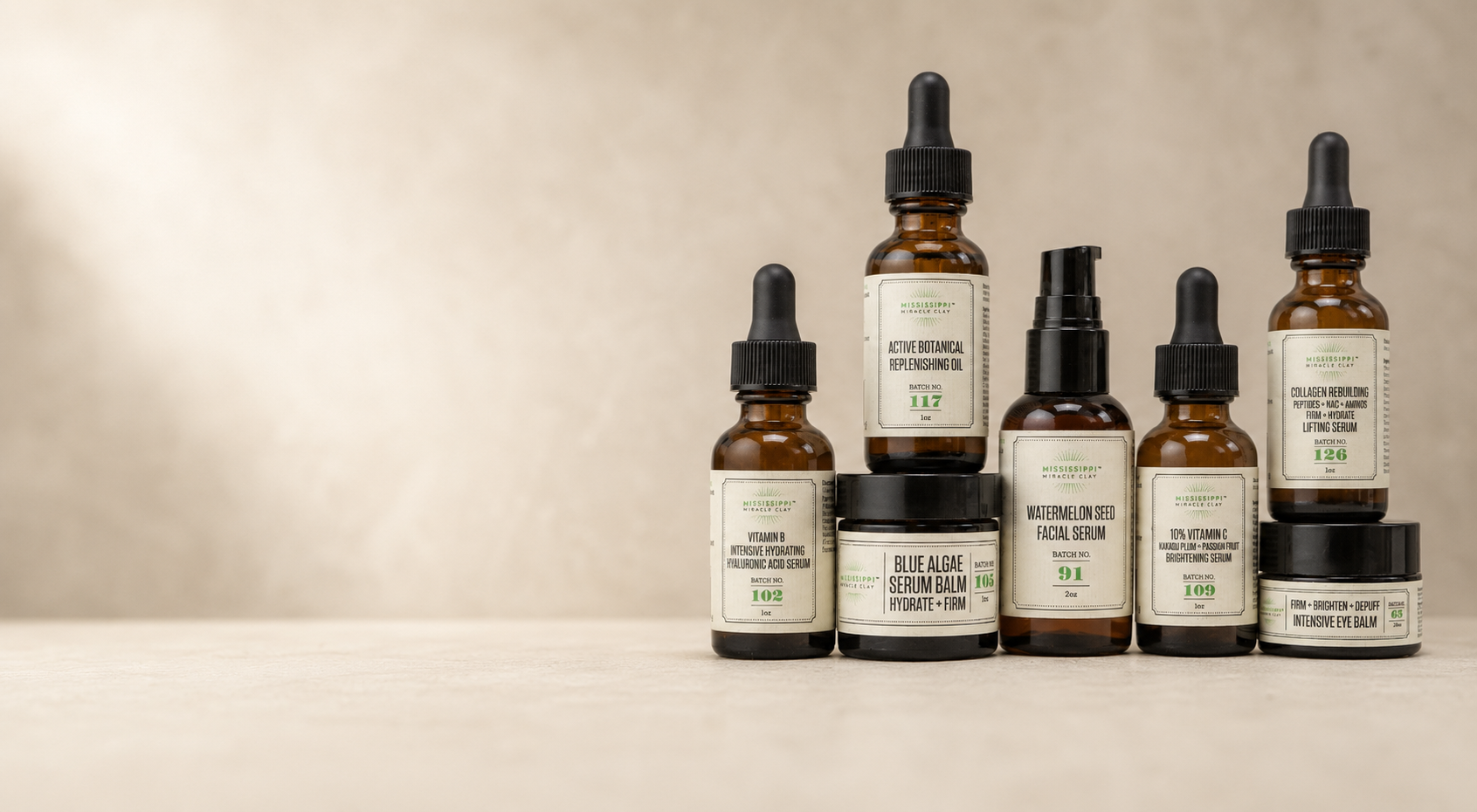 A lineup of Mississippi Miracle Clay facial serums and oils in amber glass bottles.