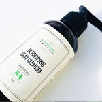 Detoxifying Clay Cleanser pump bottle held in hand