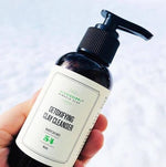 Detoxifying Clay Cleanser, a light-foaming clay cleanser, held in hand