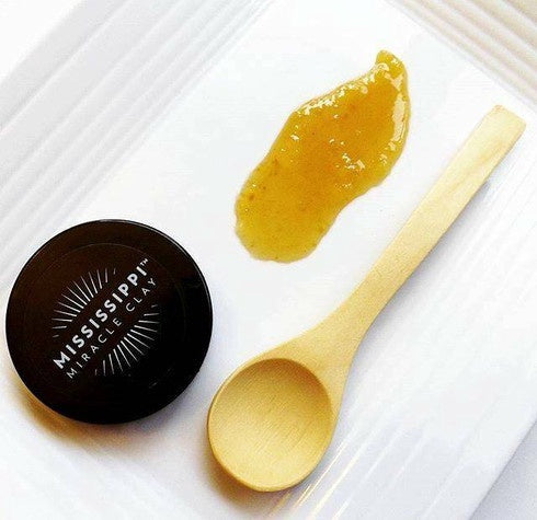 Grits and Honey Facial Scrub shown with a bowl and wooden spoon