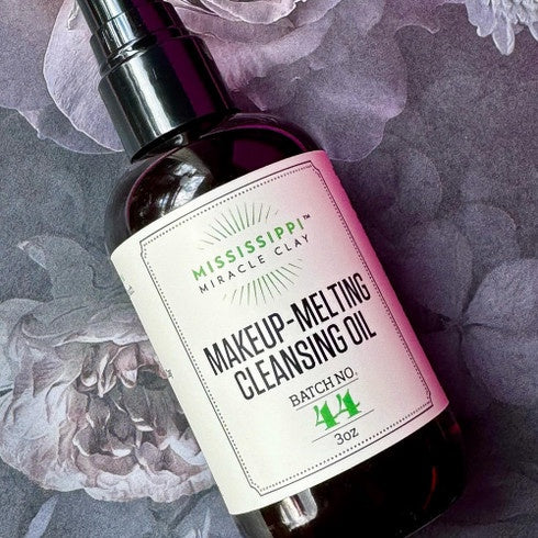 Makeup-Melting Cleansing Oil bottle styled on florals