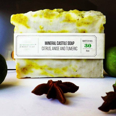 Citrus Turmeric Castile Soap bar standing with lime slices and star anise