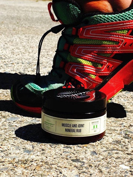 Muscle and Joint Mineral Rub beside hiking boots on a trail, natural relief after activity