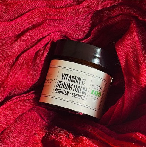 Vitamin C Serum Balm jar on red fabric